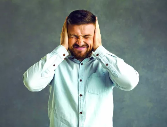 Stressed frustrated man with closed eyes and covered ears by hands squints Sumienie i jego deformacja –jak nie wpaść w pułapkę usprawiedliwienia