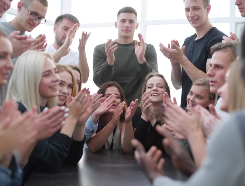 group of young diverse people applauding sitting at the same tab Jan Paweł II do młodych